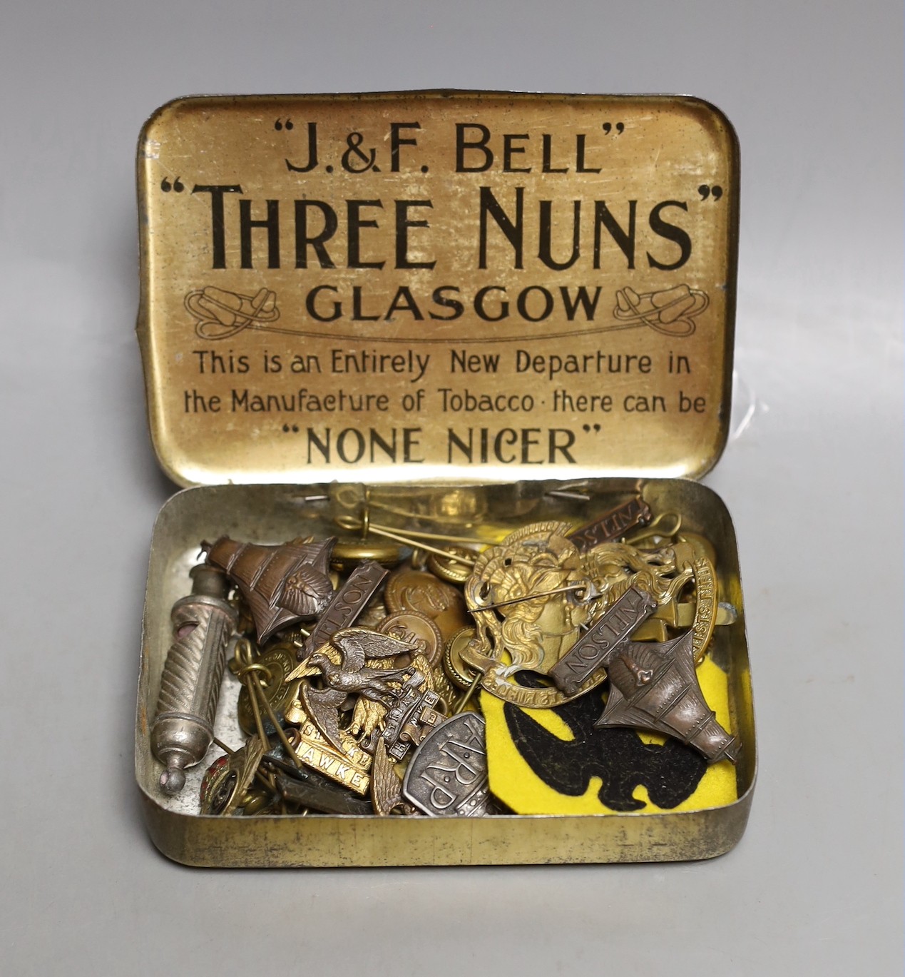 A collection of mixed cap badges and whistle